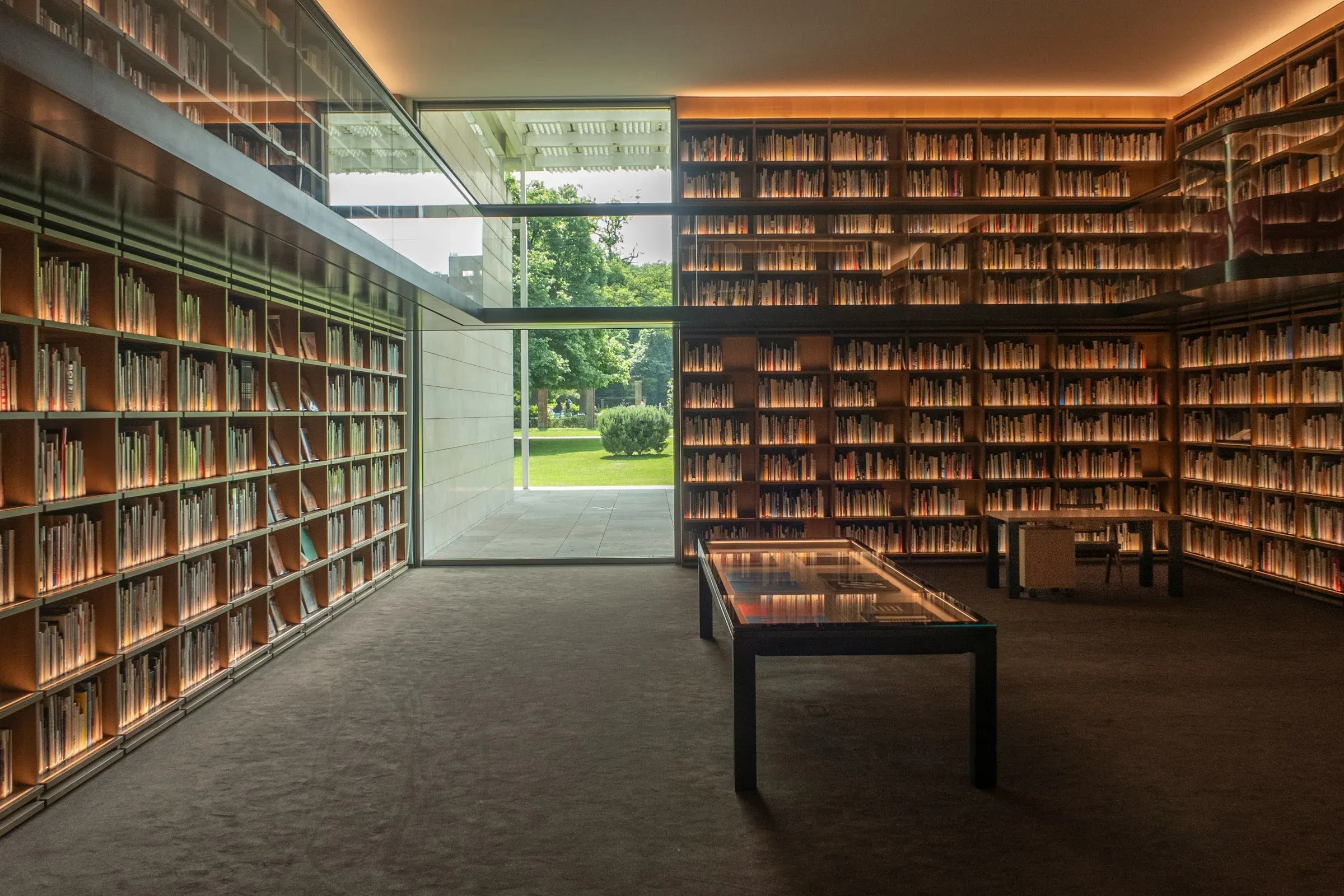 Una biblioteca moderna con estanterías de madera y luz cálida