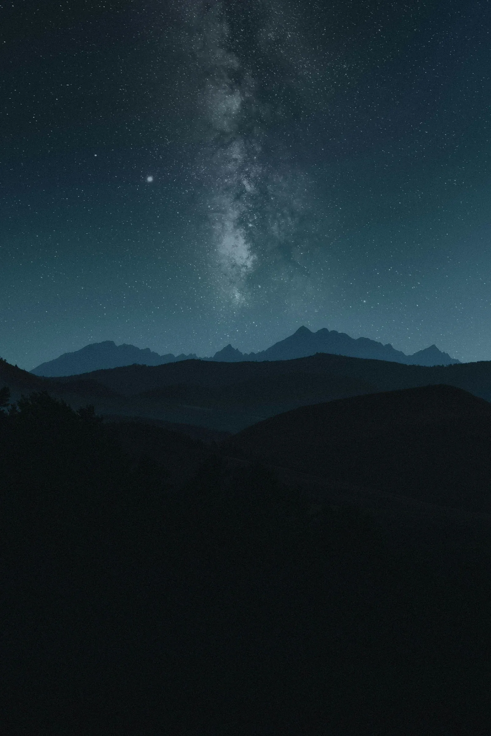 La Vía Láctea sobre la silueta de unas montañas, de noche